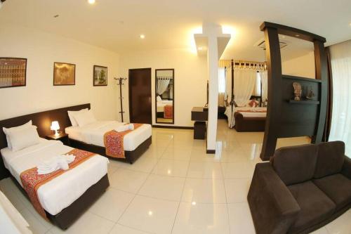 ein Hotelzimmer mit 2 Betten und einem Kreuz an der Wand in der Unterkunft Ipoh Downtown Hotel in Ipoh