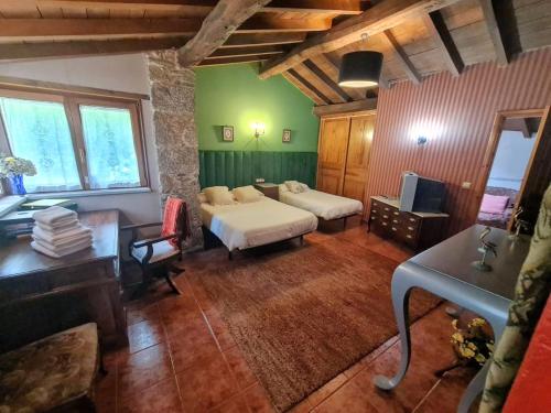 Pokój z 2 łóżkami, biurkiem i telewizorem w obiekcie A Pontiga I Casa Rural w mieście Mezonzo