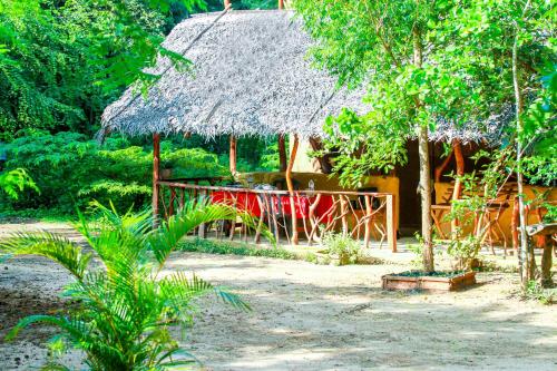 a hut with a red table in front of it at Relax Nature Villa in Sigiriya