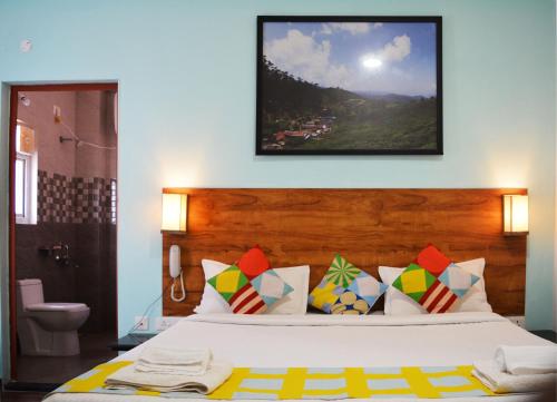 a bedroom with a bed with a picture on the wall at EDEN Paradisee in Ooty