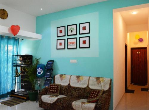 a living room with a couch and a blue wall at EDEN Paradisee in Ooty
