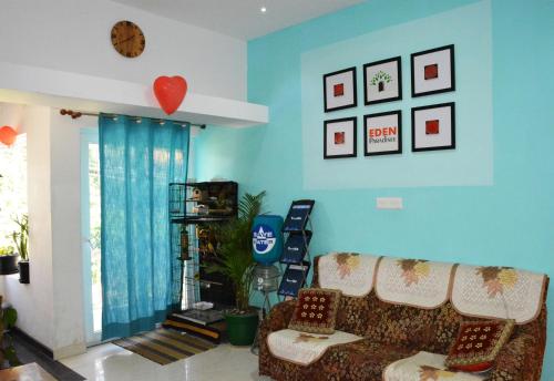 a living room with blue walls and a couch at EDEN Paradisee in Ooty