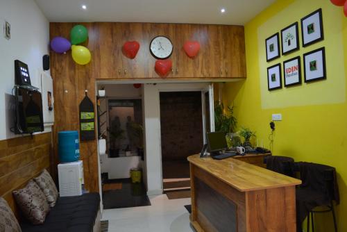 a room with a desk and a clock on the wall at EDEN Paradisee in Ooty