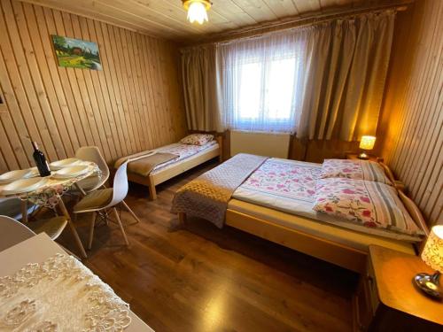 ブコビナ・タトシャンスカにある,, U Nikoli"のベッドルーム1室(ベッド2台、テーブル、窓付)