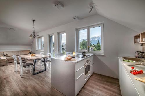 een keuken en eetkamer met een tafel en stoelen bij Vila Vernig in Bled