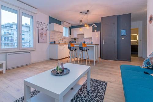 Il comprend un salon avec une table blanche et une cuisine. dans l'établissement L'impasse d'Or - Thionville, Metz, Luxembourg, à Thionville