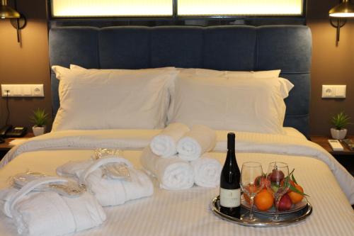 a bed with towels and a bottle of wine and fruit at FILEO ELEGANT LIVING in Veria