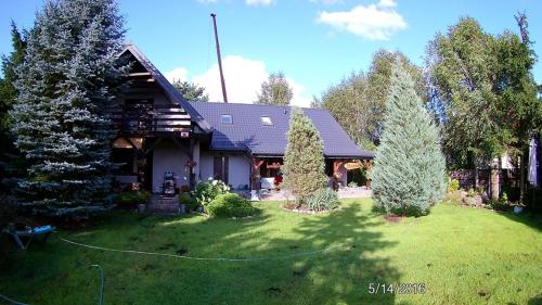 a house with a yard with trees in front of it at Chataa in Szczechy Małe