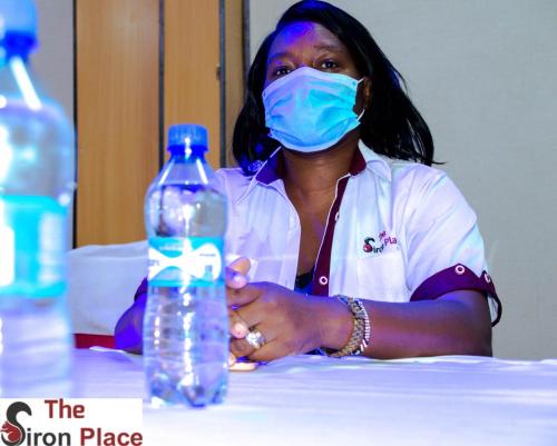 a woman wearing a mask next to a bottle of water at The Siron Place Hotel in Ongata Rongai 