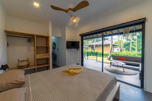 ein Schlafzimmer mit einem Bett und einer Glasschiebetür in der Unterkunft Suan Residence - Exotic and Contemporary Bungalows with Private Pool in Chaloklum