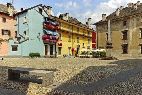 un groupe de bâtiments et un banc dans une cour dans l'établissement Il vicolo By Turistica, à Domodossola