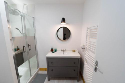 W łazience znajduje się umywalka i lustro. w obiekcie AppartUnique - Chez Helder w mieście Vichy
