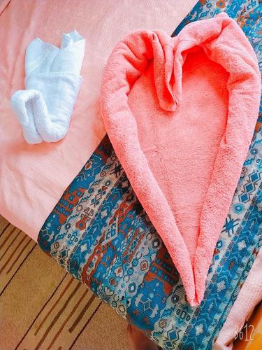 a pink heart on a bed next to a towel at Lagona Dahab Hotel in Dahab