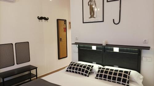 a bedroom with a bed with black and white pillows at El Duende del Tejar in El Gastor