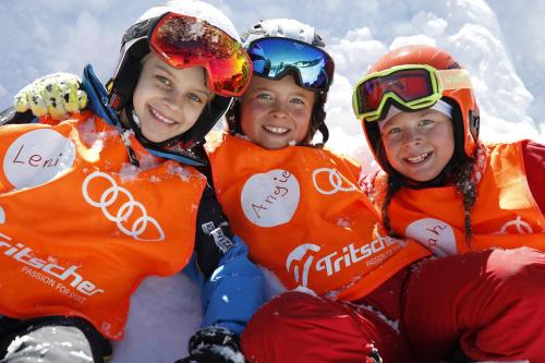 a group of three children sitting in the snow at Bergchalet Raffalt in Rohrmoos
