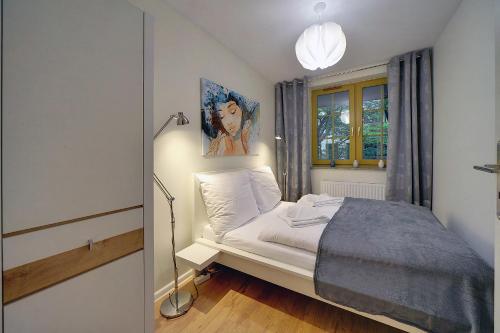 シュクラルスカ・ポレンバにあるApartamenty EverySky - Osiedle Podgórze 1Dのベッドルーム1室(ベッド1台、ランプ、窓付)