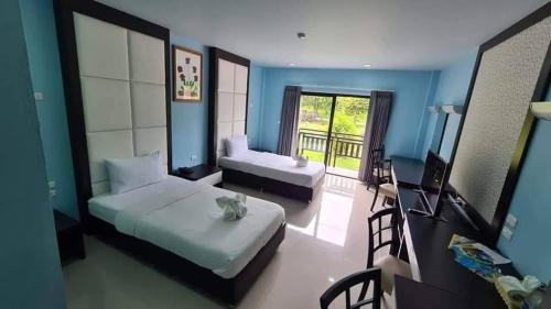 a bedroom with a bed and a couch and a television at The Thai Elephant Conservation Center Lampang in Lampang
