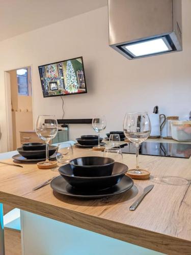 una mesa con platos y copas de vino. en Séjour cocooning pour se ressourcer à la montagne. en Aulus-les-Bains