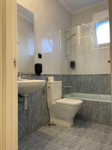 a bathroom with a toilet and a sink at Pensión Belmonte - check in Hotel a 650 metros in Gijón