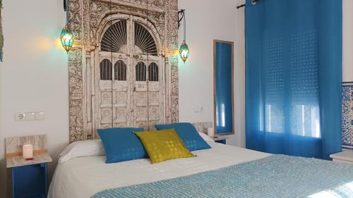 エル・ガストルにあるEl Duende del Tejarのベッドルーム1室(青と黄色の枕が備わるベッド1台付)