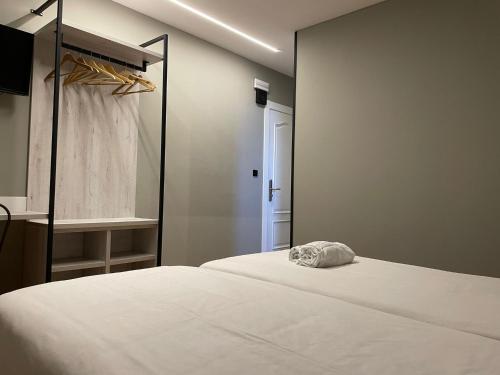 1 dormitorio con cama blanca y ventana en Belmonte Rooms, en Gijón