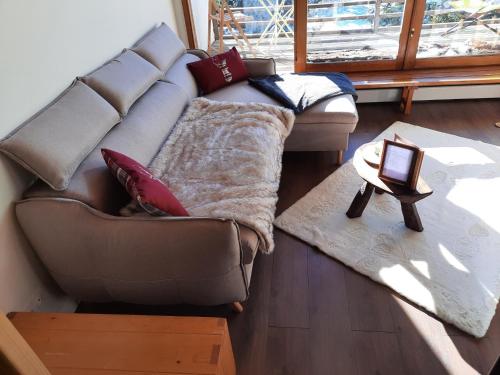 un salon avec un canapé et une table dans l'établissement Superbe 2 pcs cabine terrasse vue féérique pistes et montagnes, à Auron
