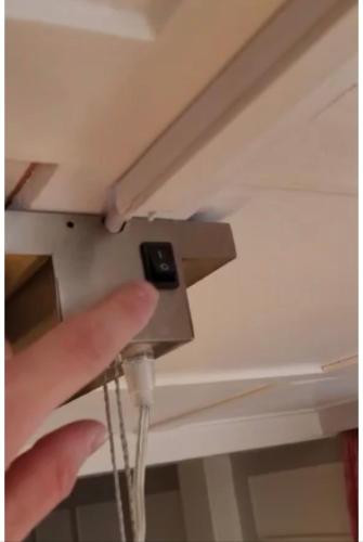 a hand holding a device on a ceiling at Charming Swiss Chalet Andermatt in Andermatt