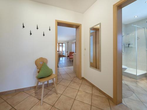a bathroom with a shower and a chair with a pillow at Gästehaus Bernhard in Krün