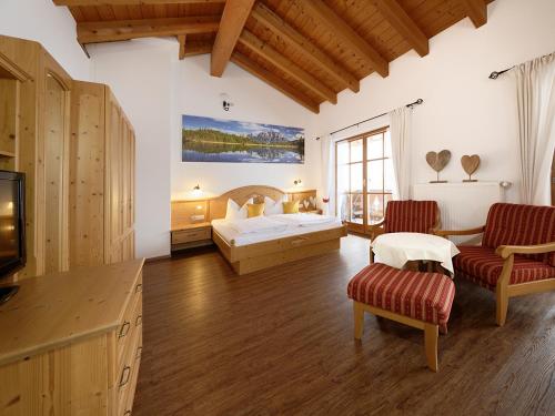 a bedroom with a bed and a tv in a room at Gästehaus Bernhard in Krün