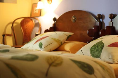 a bed with a wooden headboard and pillows at Hotel La Posada de Lalola in Buera