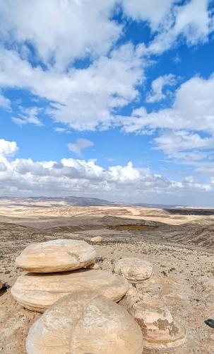 four rocks sitting on top of a desert field at Vastu Dead Sea apartment in Arad
