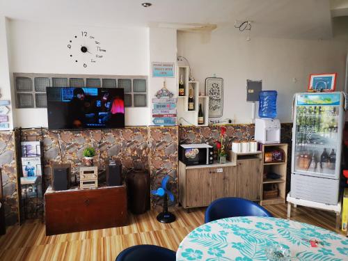 una habitación con una mesa y un reloj en la pared en Country Bug Inn, en Tagaytay
