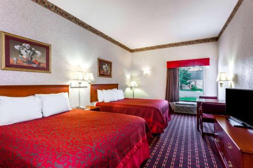 um quarto de hotel com duas camas e uma televisão de ecrã plano em Days Inn by Wyndham Manassas em Manassas