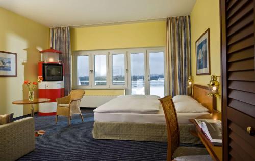 ein Hotelzimmer mit einem Bett und einem TV in der Unterkunft Wyndham Stralsund HanseDom in Stralsund