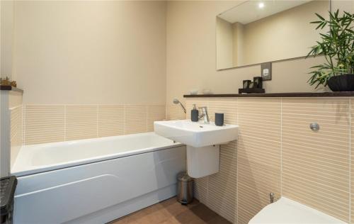 La salle de bains est pourvue d'un lavabo, de toilettes et d'une baignoire. dans l'établissement Dreamhouse at Oswald Street, City Centre, à Glasgow