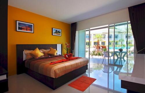 a bedroom with a bed with orange walls and a balcony at Gypsy Sea View Resort in Phi Phi Islands