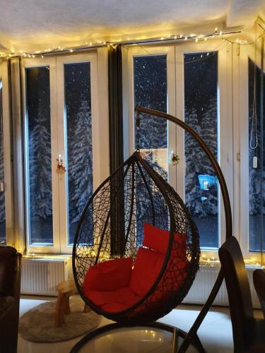 a swing chair sitting in front of a window at Home Belić Golija in Radaljica