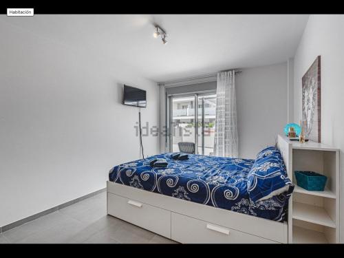een witte slaapkamer met een bed en een raam bij Sunbeach Apartment La Tejita in Granadilla de Abona