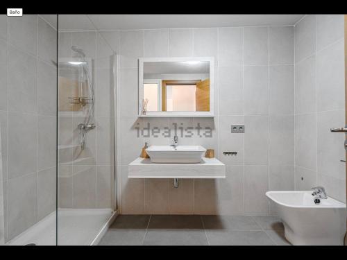 a white bathroom with a sink and a shower at Sunbeach Apartment La Tejita in Granadilla de Abona