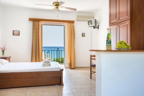a hotel room with a bed and a view of the ocean at Stefanos Studios in Lourdhata