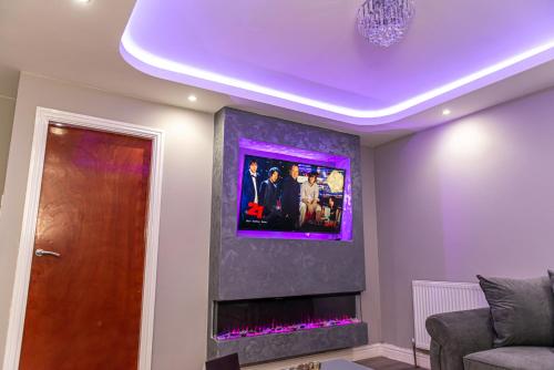 a living room with a fireplace with a tv on the wall at Meridian Serviced Apartments in Bradford