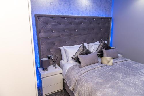 a bedroom with a large bed with a blue wall at Meridian Serviced Apartments in Bradford
