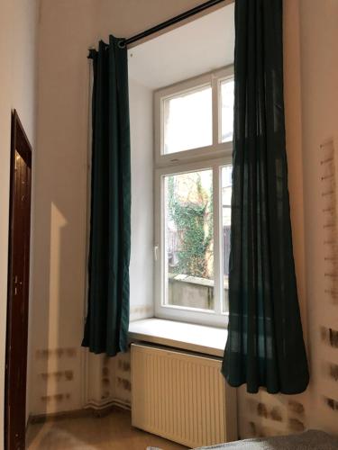 a window with green curtains in a room at Nr 3 in Kraków