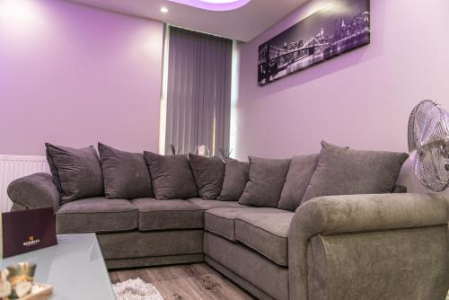 a living room with a couch and a fan at Meridian Serviced Apartments in Bradford