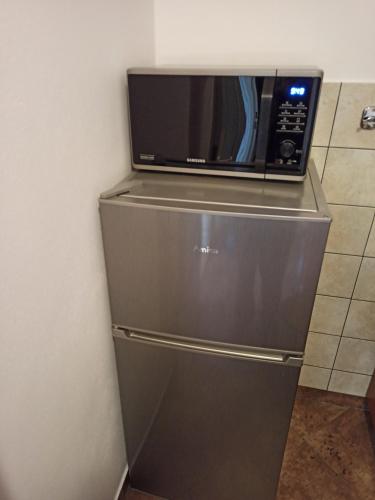 a microwave sitting on top of a refrigerator at Apartament przy Stoku in Krynica Zdrój