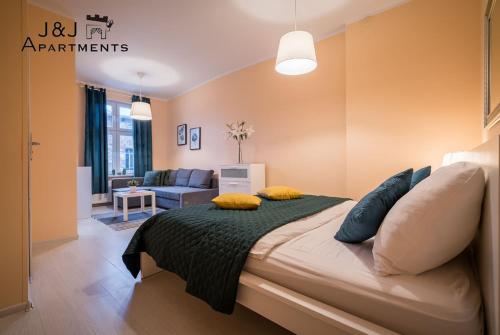 een slaapkamer met een bed met gele kussens erop bij J&J Apartments - Szeroka 25, Apartament 5B in Toruń