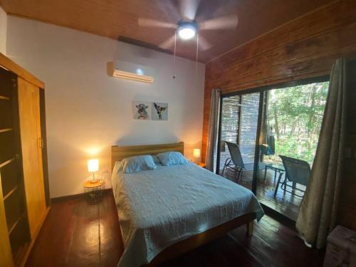 a bedroom with a bed and a large window at Casa Natural Madera in Brasilito