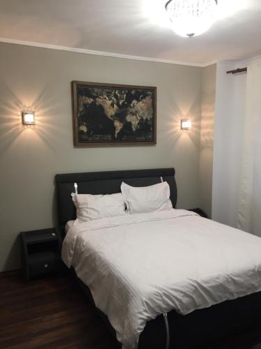 um quarto com uma cama branca e 2 almofadas em Spa-ul Schiorilor em Predeal