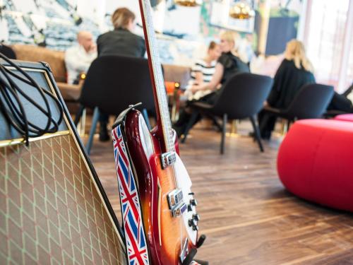 a guitar sitting on the floor in a room at Motel L Hammarby Sjöstad in Stockholm