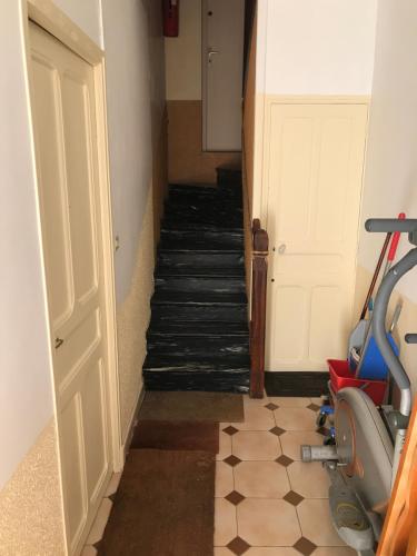a hallway with a staircase with a treadmill and a door at Hébergements à La Rive, Accueil ouvert tous les jours jusqu'à 20h00 dernier délai, depuis 30 ans ! Réserver ici svp ! Merci ! Aucun règlement à distance accepté, Paiement par CB, Espèces, Chèque ou Chèques-Vacances impérativement à la remise des clefs ! in Amélie-les-Bains-Palalda